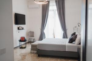 ein Schlafzimmer mit einem Bett und einem großen Fenster in der Unterkunft La Residenza del Barone in Camerota