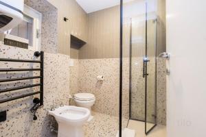 a bathroom with a toilet and a glass shower at Bocadasse Beach| Wifi| Boho Luxury By Tilo in Genova