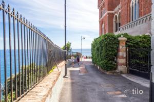 a fence on the side of a building next to the ocean at Bocadasse Beach| Wifi| Boho Luxury By Tilo in Genova