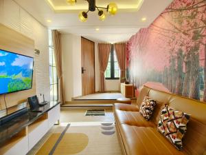 a living room with a couch and a tv at Quattrick Villa in Tlekung