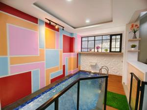 a pool in a room with a colorful wall at Quattrick Villa in Tlekung