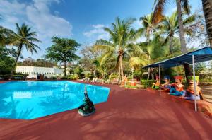 un grupo de personas sentadas alrededor de una piscina en Ambassador Ajanta Hotel, Aurangabad, en Aurangabad