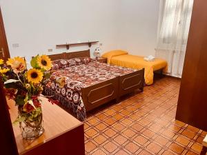 Pokój z dwoma łóżkami i wazą kwiatów w obiekcie Albergo Belvedere w mieście Maissana