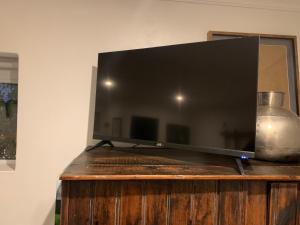 a flat screen tv sitting on top of a wooden stand at The Hedge Cottage in Riebeek-Kasteel