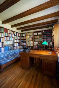een bibliotheek met een bureau en veel boeken bij Epidaurus Olive Villa in Néa Epídhavros