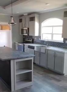 a large kitchen with white cabinets and a large island at SLCa in Austin