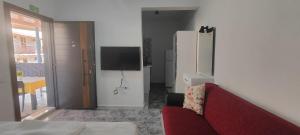 a living room with a red couch and a tv at Neşe &Alp Apart Pansiyon in Demre