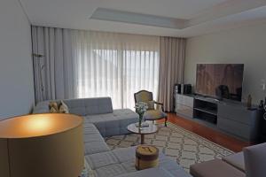 a living room with a couch and a tv at Ocean escape with private pool in Arco da Calheta