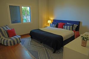 a bedroom with a large bed and a chair at Ocean escape with private pool in Arco da Calheta