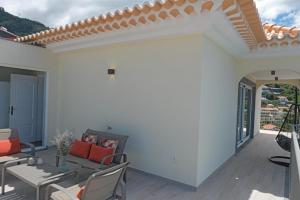 a patio with a couch and a table and chairs at Ocean escape with private pool in Arco da Calheta +36 photos