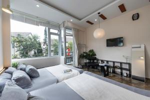 a living room with a couch and a large window at LOMO house in Khu Chi Lăng