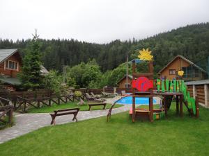 a park with a playground with a slide and benches at Villa Provans in Tatariv