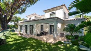une grande maison blanche avec une grande cour dans l'établissement Villa Dasha by the Lake, à Quinta do Lago