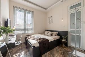 a bedroom with a bed and a desk and a window at LOMO house in Khu Chi Lăng