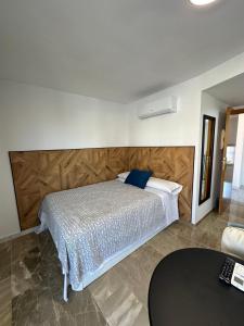 a bedroom with a bed with a wooden headboard at Apartamentos El Tranco del Mar in Almuñécar