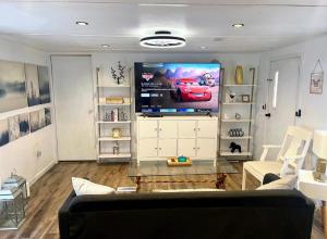 een woonkamer met een bank en een flatscreen-tv bij Urban Chic Trailer in Edmond