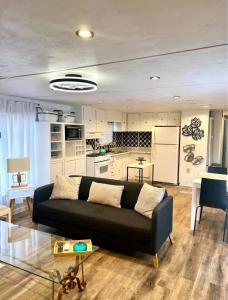 een woonkamer met een zwarte bank en een keuken bij Urban Chic Trailer in Edmond