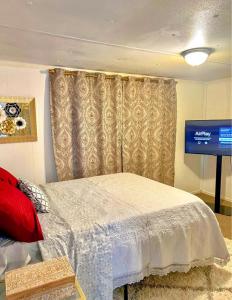 een slaapkamer met een bed en een tv in een kamer bij Urban Chic Trailer in Edmond