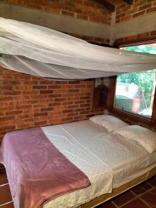 a bed in a room with a brick wall at Habitación privada in Santa Marta +46 photos