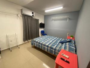 a bedroom with a bed and a red chair at Hostal TO3 in Ciudad Madero