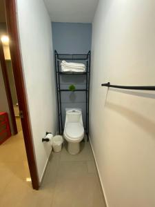 a bathroom with a toilet and a towel rack at Hostal TO3 in Ciudad Madero