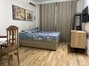 a bedroom with a bed and a desk and a chair at 360 Santa Tereza by SUHCasa in Rio de Janeiro