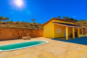 a yellow house with a swimming pool in front of it at Pousada Recanto Dilello in Socorro