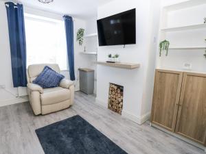 a living room with a chair and a fireplace at Keekle Terrace in Cleator Moor