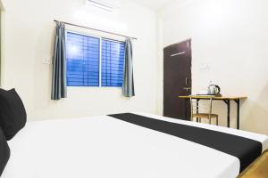 a bedroom with a bed and a window at Hotel O CityMax in Jabalpur