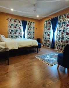a bedroom with a bed with blue curtains at Whistling Woods Eco Resort 