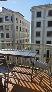 a table and chairs on a balcony with buildings at Beach Big Apartment With 3 Rooms Apartment Parking Included in San Sebastián