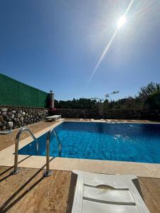 a swimming pool with the sun in the sky at Keskin Villa Köyceğiz in Koycegiz