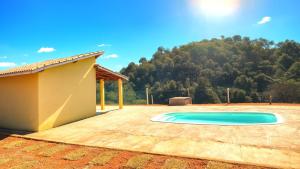 a swimming pool in a yard next to a house at Pousada Recanto Dilello in Socorro