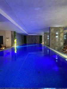 Una gran piscina con luces azules en un edificio. en Tomi Lux, en Zlatibor