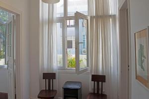 una stanza con due sedie e una finestra di Traditional apartment with garden a Lisbona Altre 27 foto