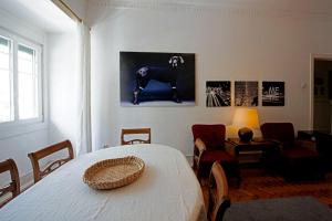 ein Wohnzimmer mit einem Tisch und ein Zimmer mit einem Stuhl in der Unterkunft Traditional apartment with garden in Lissabon