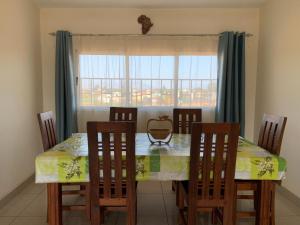 a dining room with a table with chairs and a window at La Komnata in Antsirabe