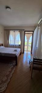 a bedroom with a bed and a table and windows at Zamia Heights Apartments in Gatunga