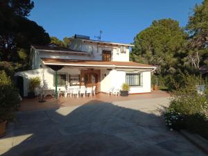 a white house with a patio and tables and chairs at Boutique Algarrobo in Denia