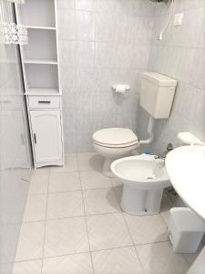 Un baño blanco con inodoro y lavabo. en Residence Delle Rose Lido Marini, en Lido Marini 28 fotos más