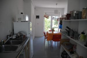 a kitchen with a sink and a table with chairs at Első Ház Tagyon in Tagyon