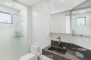 a bathroom with a sink and a toilet and a mirror at Apto c/ Churrasqueira a 550m da Praia UPS1002 in Perequê +21 photos