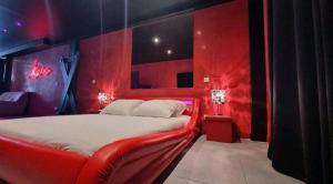 a red bedroom with a bed with a red wall at Appartement balnéo et sauna privés The Red Room in Mauguio