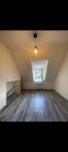 an attic room with a window and a wooden floor at Duplex plage de brehec in Plouézec