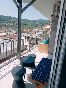 a balcony with two stools and a bench and a view at HOLLYWOOD Skiathos in Skiathos
