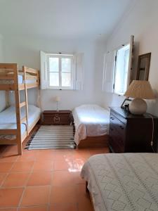 a bedroom with two beds and a desk and a bunk bed at Monte Horta da Velhinha in Redondo