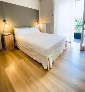 - un grand lit blanc dans une chambre dotée de parquet dans l'établissement cozy isola garden, à Milan