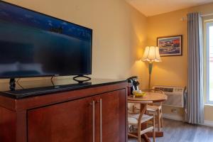 a living room with a large flat screen tv at Hotel Cowansville in Cowansville