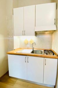 une cuisine avec des armoires blanches et un évier dans l'établissement cozy isola garden, à Milan 14 autres photos