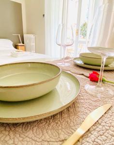 une table avec des assiettes et des verres à vin dessus dans l'établissement cozy isola garden, à Milan